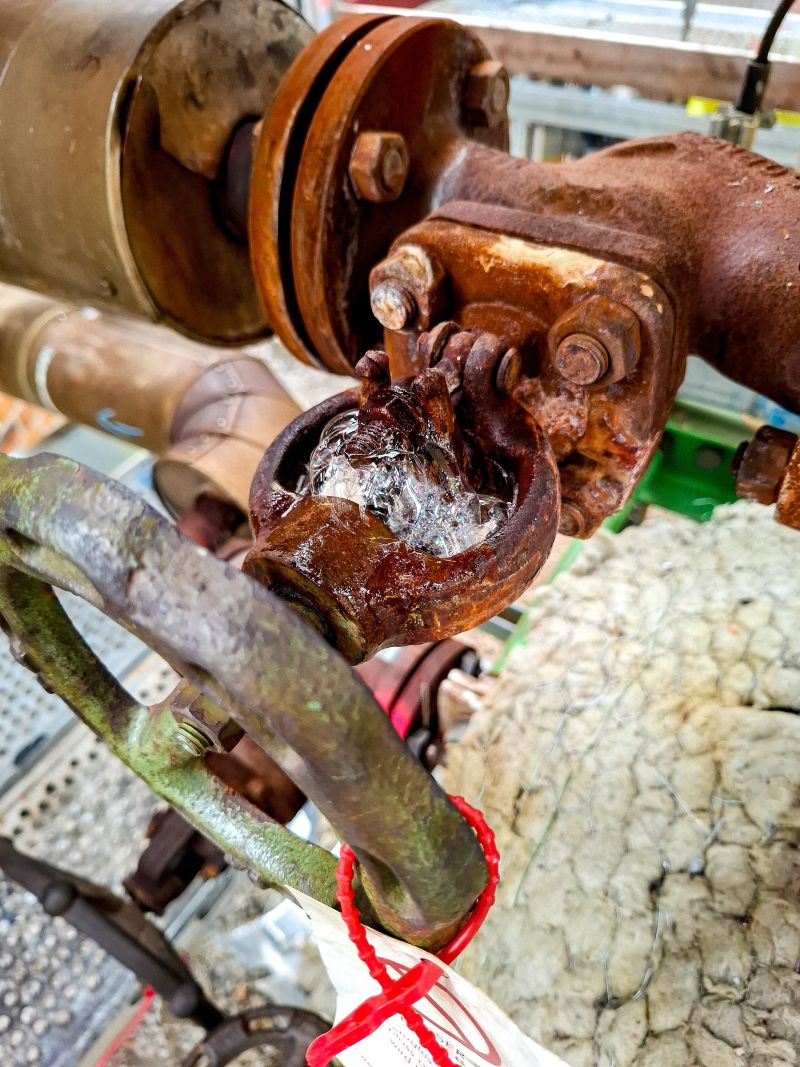 Iced valve at a flange connection, frost forming from escaping medium