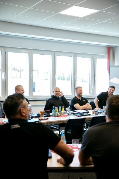 Participants of the IDT–Steffca workshop seated at conference tables in a bright meeting room
