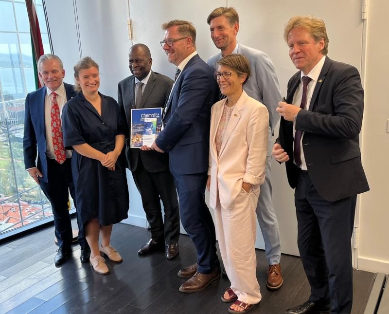 Delegation members presenting a brochure about Chemnitz in Mozambique